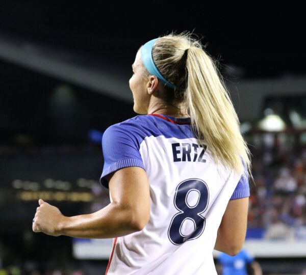 Julie Ertz on the field at her final USWNT game, showing the back of her #8 jerseys while she looks to the stands.