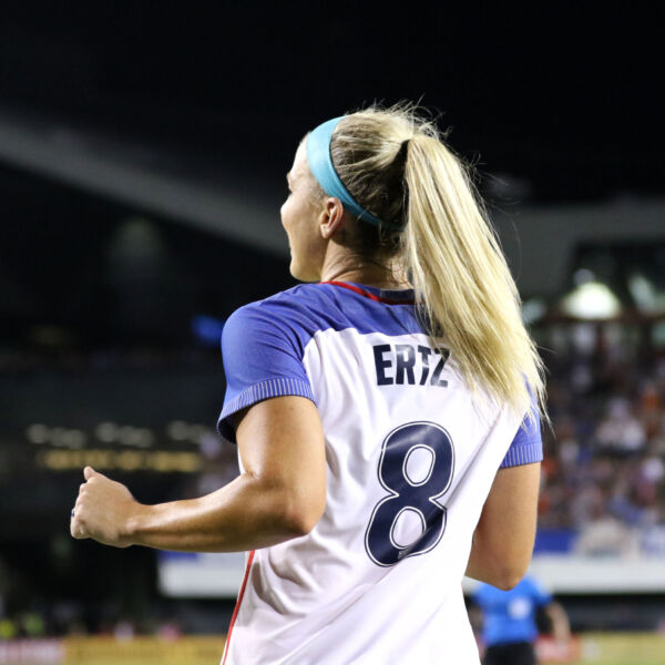 Julie Ertz on the field at her final USWNT game, showing the back of her #8 jerseys while she looks to the stands.