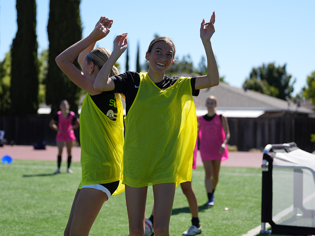 Teammates in yellow training bibs celebrating together during LGU summer programs in 2026.