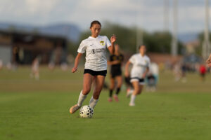 Los Gatos United goalkeeper in pink kit playing the ball