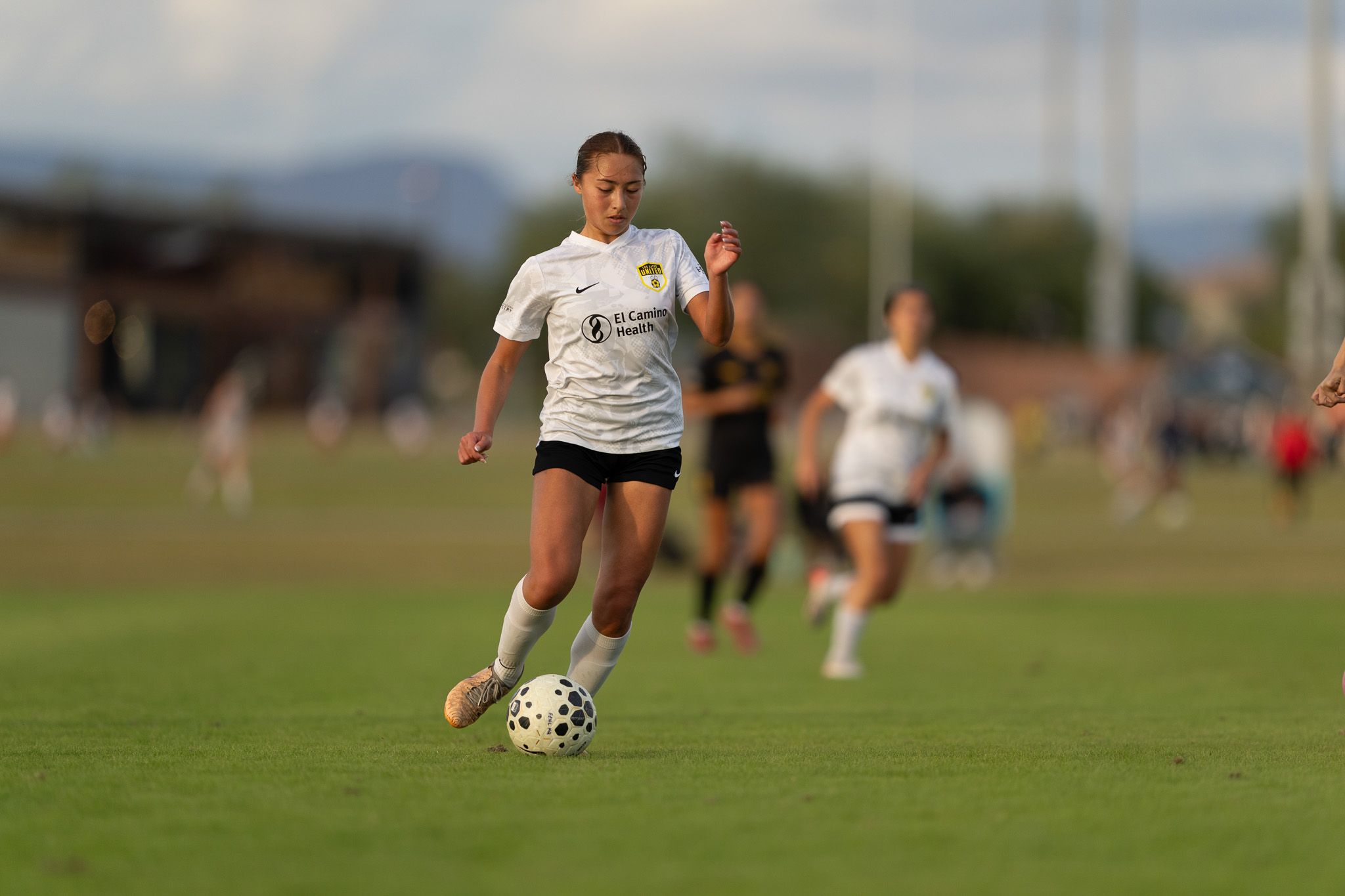Los Gatos United goalkeeper in pink kit playing the ball