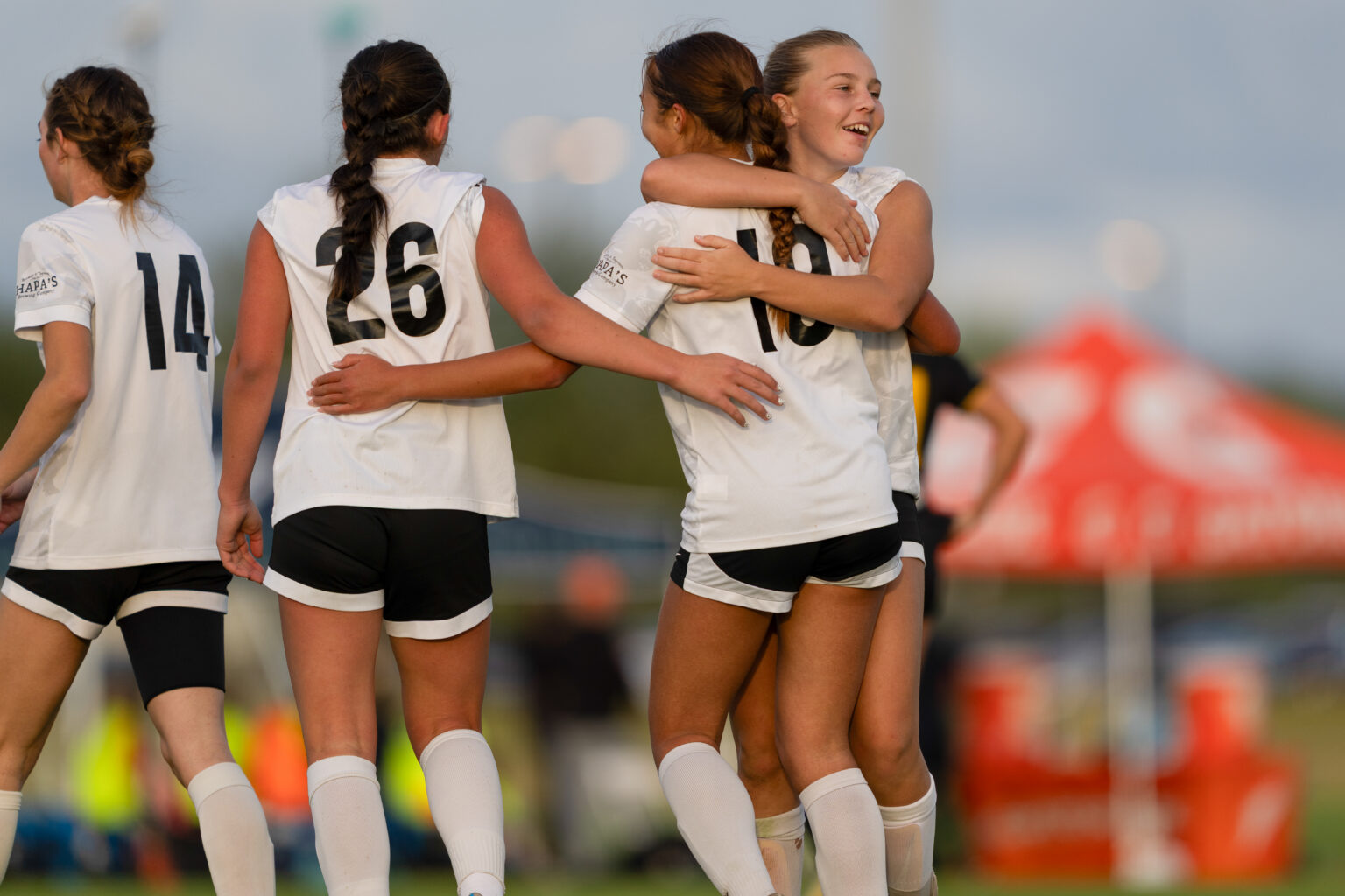 Los Gatos United girls in white match jerseys celebrating together